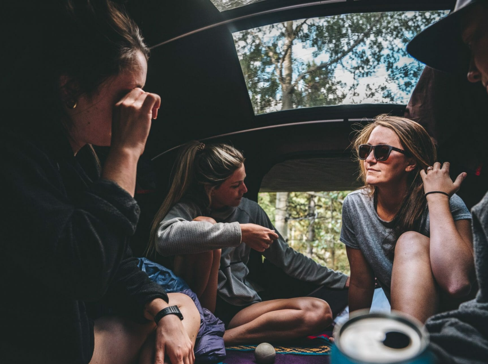 3 vriendinnen zitten in hun X-Cover harde schaal daktent en praten met elkaar