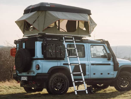 Good Vibes hardshell-daktent op een lichtblauwe auto in de bergen