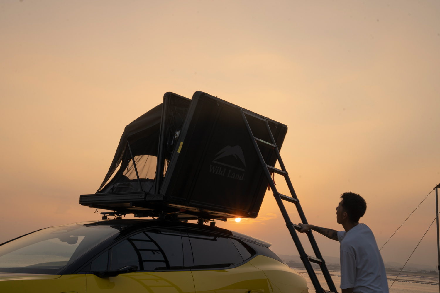 Kampeerder klimt in zijn daktent